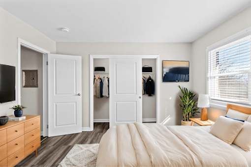 A bedroom with a large bed, a dresser, and a mirror.