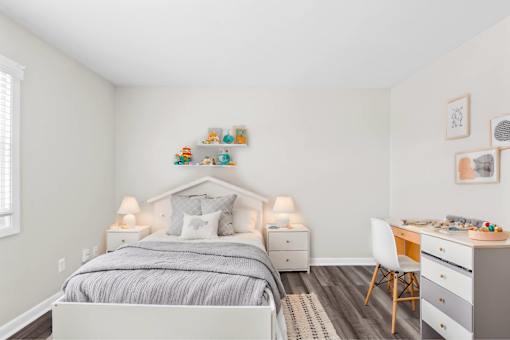A bedroom with a bed, desk, and chair.