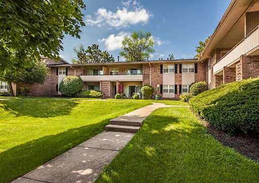 A residential building with a green lawn in front.