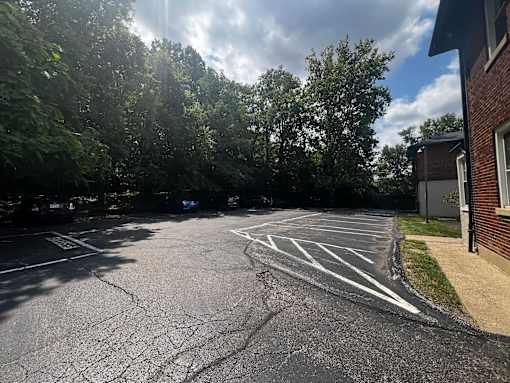 a parking lot with a building and trees at Cincinnati Premier Living*, Cincinnati