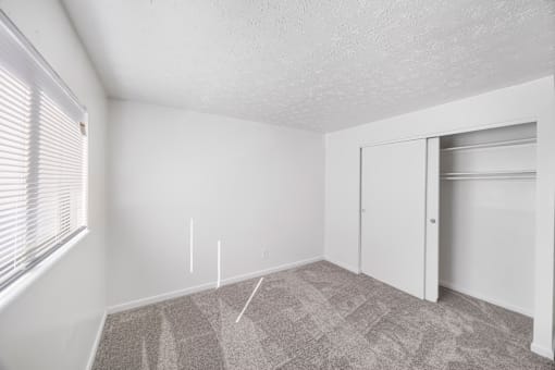A room with a carpeted floor and a white door.