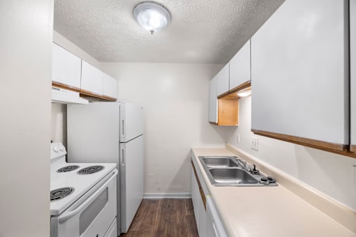 A small kitchen with white appliances and wood accents.