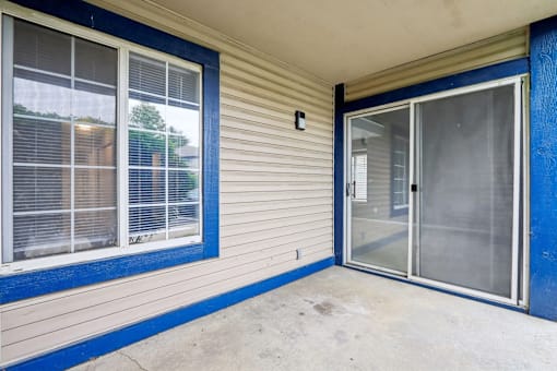 A blue and white house with a sliding glass door.