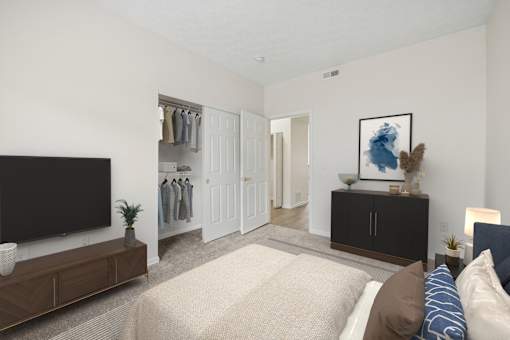 A bedroom with a large bed and a TV on the wall.