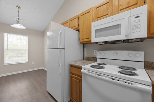 A kitchen with a white stove and a white refrigerator.