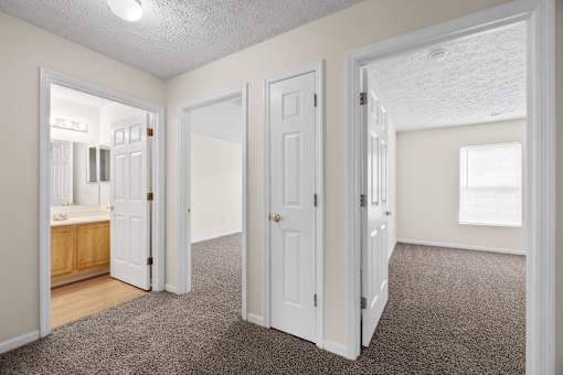 A room with white doors and a carpeted floor.