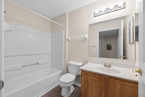 A white toilet sits in a bathroom next to a white sink.