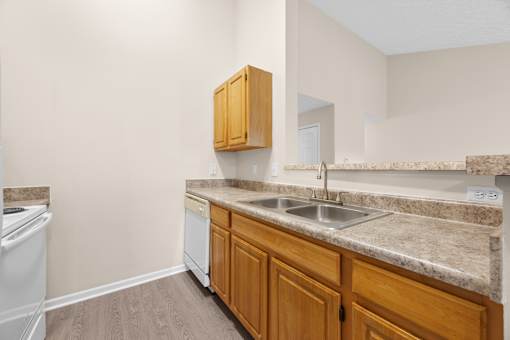 A kitchen with a white dishwasher and a white washing machine.