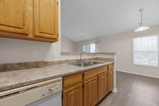 A kitchen with wooden cabinets and a granite countertop.