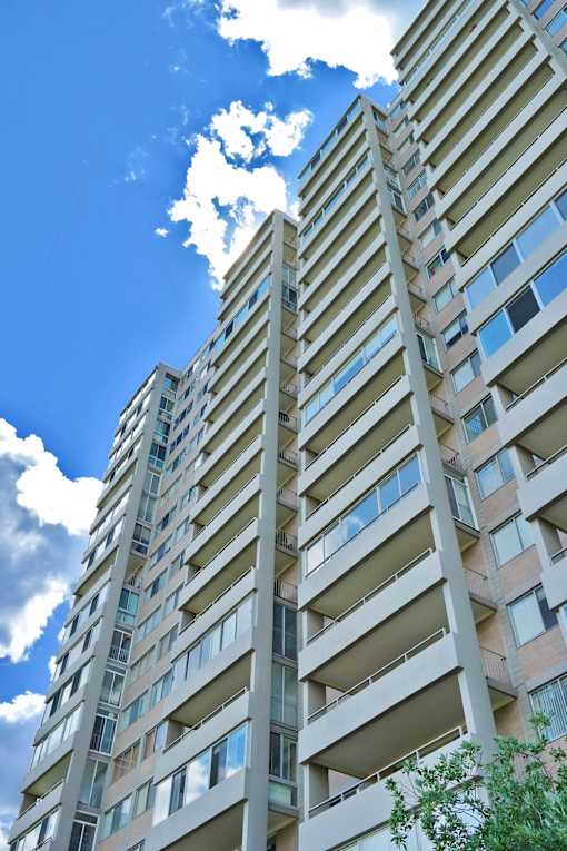A tall residential building with balconies and windows.
