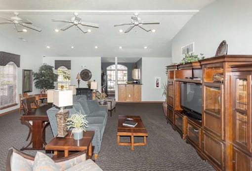 A living room with a grey couch and wooden furniture.