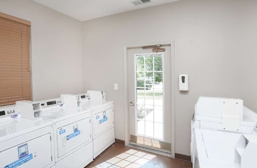 A room with a white door and a wall-mounted thermostat.