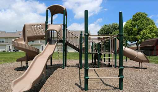 A playground with a slide and a climbing frame.