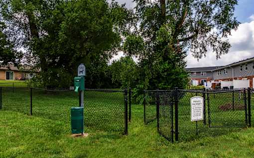 A sign in a green post in a grassy area.