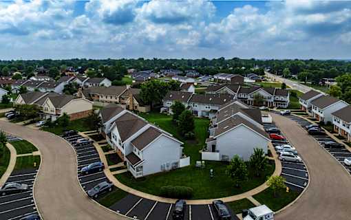 A residential area with houses and cars parked in a lot.
