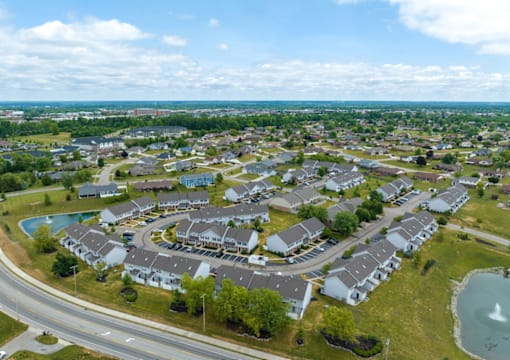 A bird's eye view of a residential area with houses and a swimming pool.