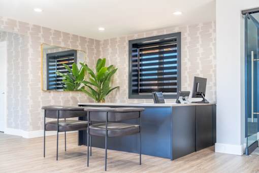 an office with two stools and a desk with a computer