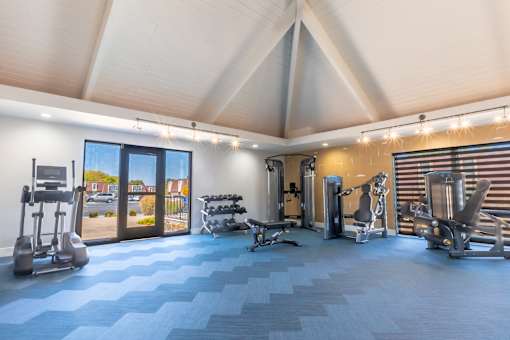 a gym with weights and cardio equipment and a glass door