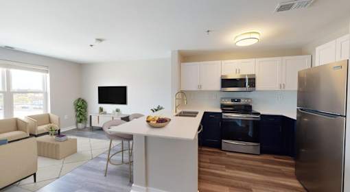 A modern kitchen with stainless steel appliances and a dining area with a table and chairs.