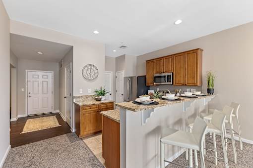 A kitchen with a white counter top and a white fridge.
