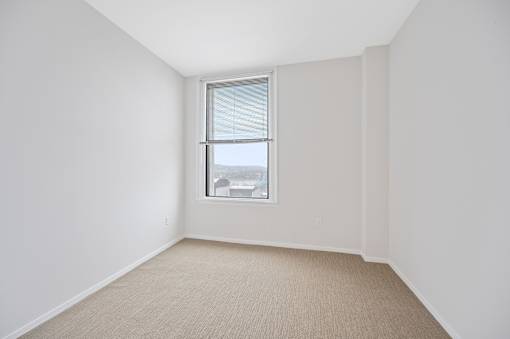 A room with a window and carpeted floor at Sky Central Apartments, Cincinnati, Ohio