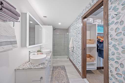 A bathroom with a sink, mirror, and shower at Sky Central Apartments, Ohio