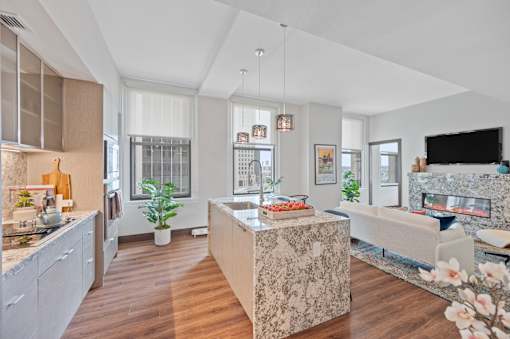 A modern kitchen with a marble island and a living room with a fireplace at Sky Central Apartments, Ohio