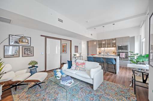 A living room with a white couch and a glass coffee table at Sky Central Apartments, Cincinnati, OH