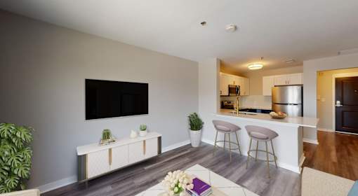 A modern living room with a flat screen TV mounted on the wall.