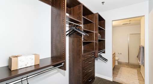 A room with a white wall and a brown box on a shelf.