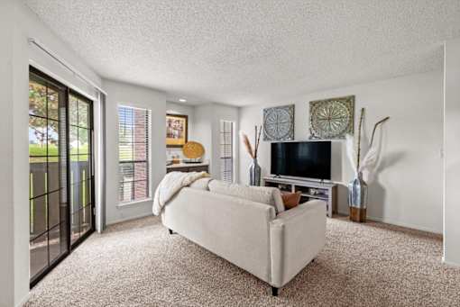 A living room with a white couch and a television.