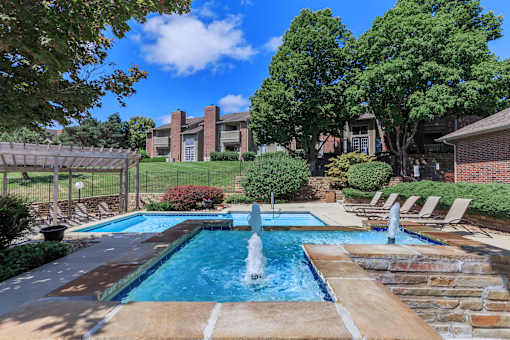 A pool with a fountain in the middle of it.