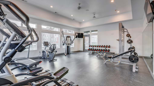 A spacious gym with a variety of equipment including treadmills, weights, and exercise machines.