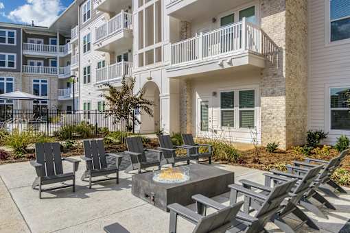 A patio with chairs and a table in front of a building.