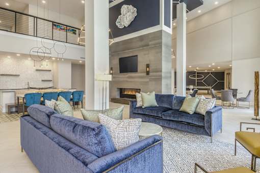 A living room with blue couches and a fireplace.