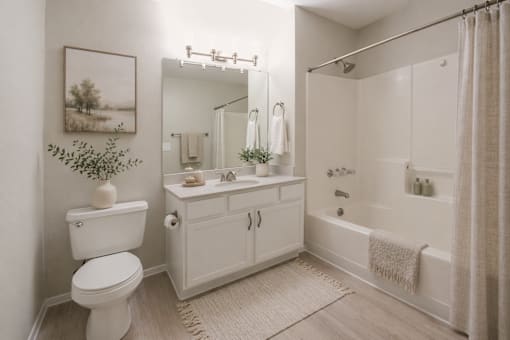 A white bathroom with a toilet, sink, and bathtub.