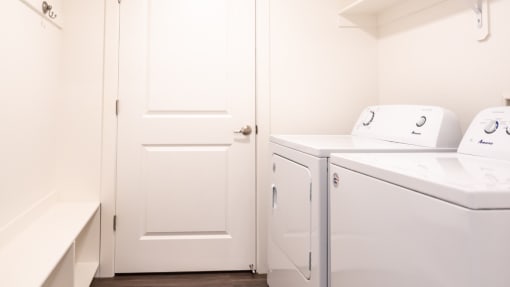a laundry room with a washer and dryer and a white door