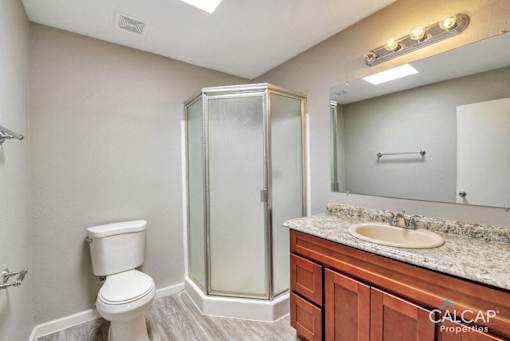 A bathroom with a toilet, sink, and shower.