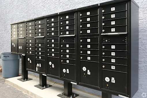 A row of black mailboxes with numbers on them.