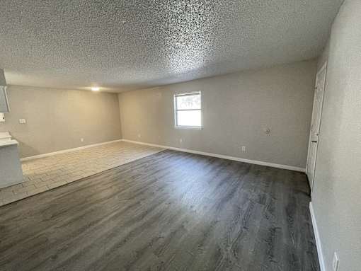 A room with a window and wooden flooring.