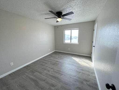 A room with a ceiling fan and a window.