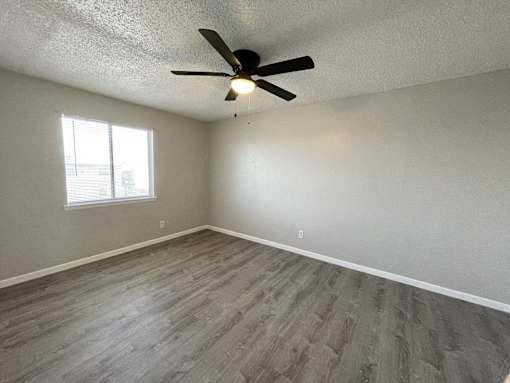 A room with a ceiling fan and a window.