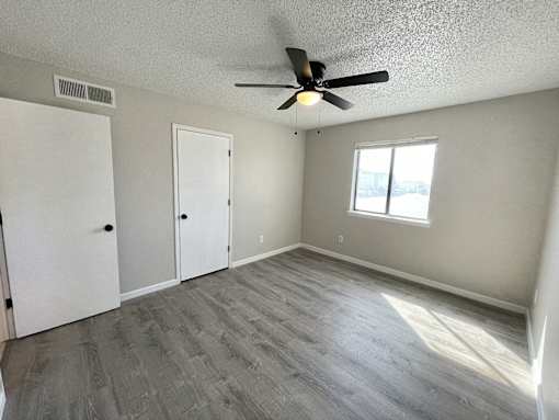 A room with a ceiling fan and a window.