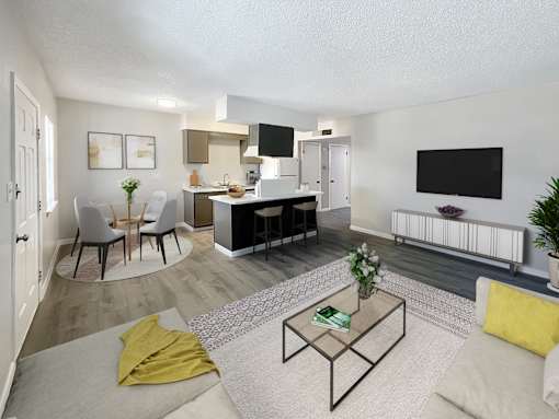 A living room with a white couch, a coffee table, and a television.