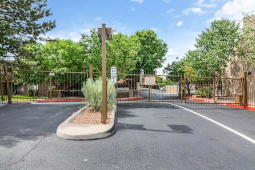 A parking lot with a sign and a gate.