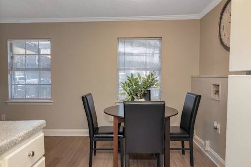A dining room with a table and chairs.