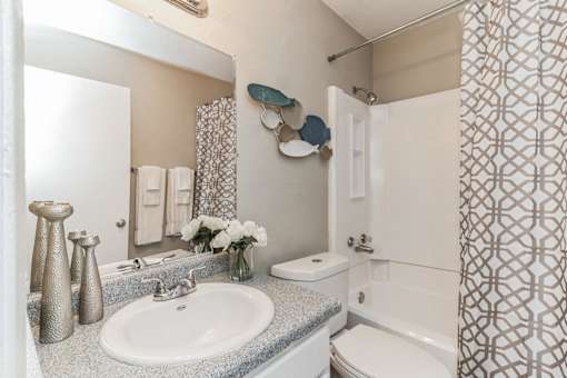 A bathroom with a white sink and a white toilet.