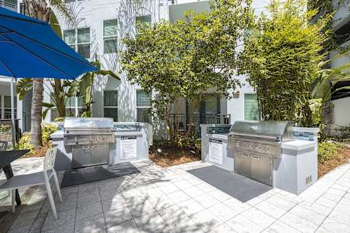 A BBQ grill is set up outside in a courtyard.