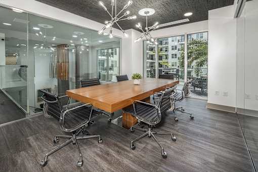 A conference room with a long table surrounded by chairs.