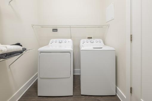 Two white front loading washing machines in a laundry room.